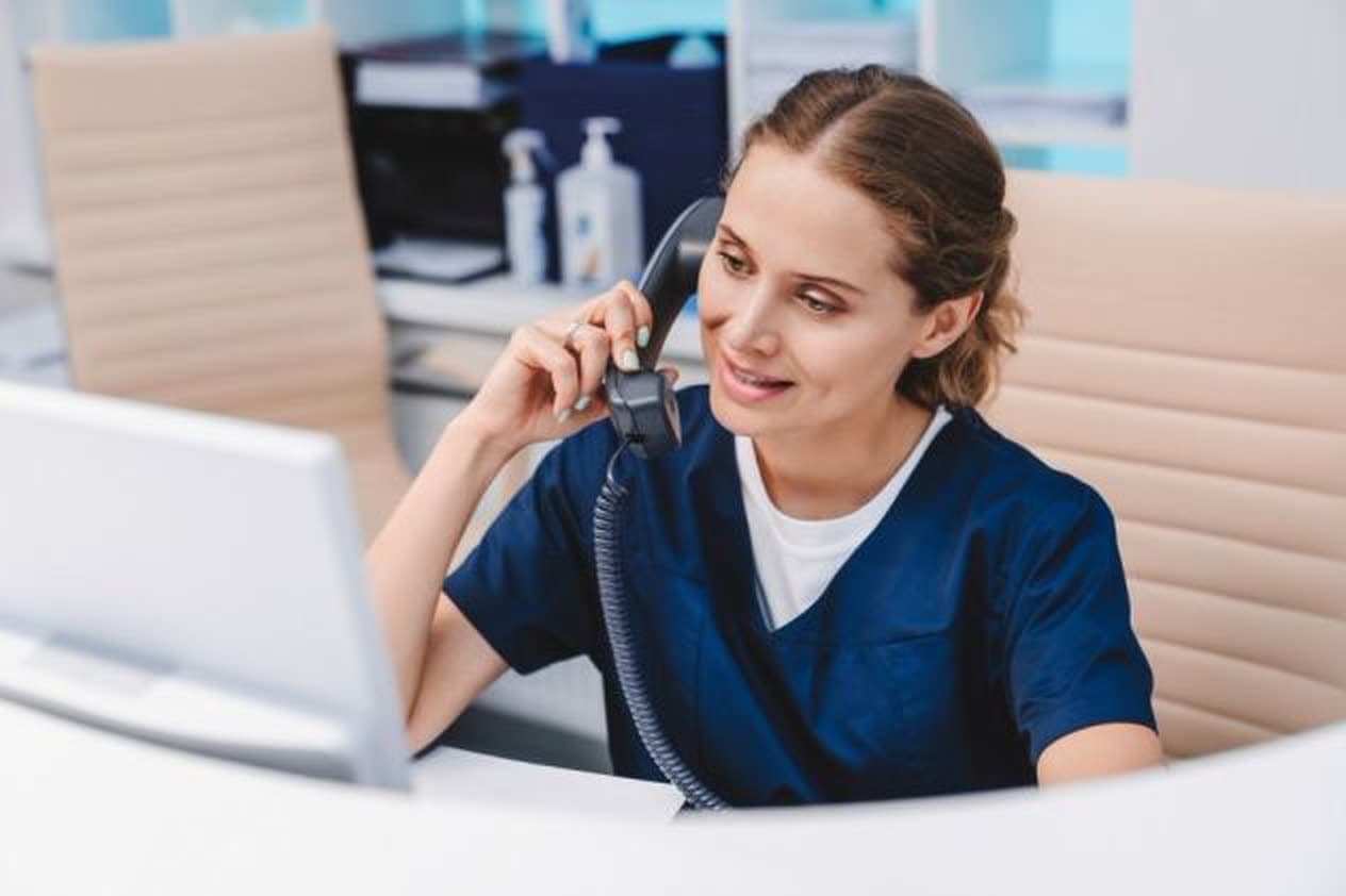 Secrétaire médicale au téléphone à l’accueil d’un cabinet