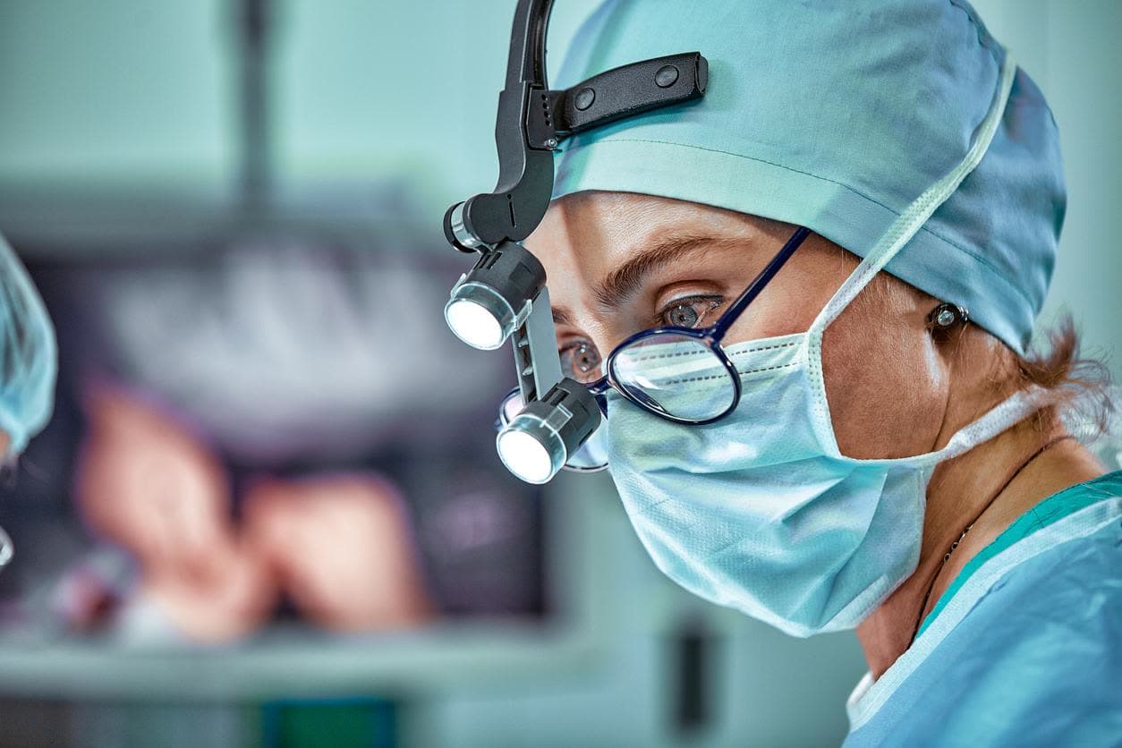 Praticienne en intervention, loupes chirurgicales